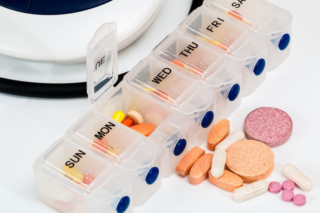 Weekly pill organiser containing medicines and vitamins